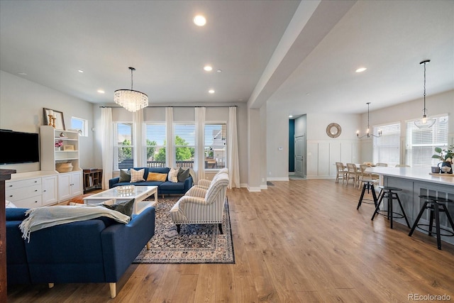 5663 W 96th Ave, Westminster, CO 80020 - living room featuring a chandelier, wood finished floors, recessed lighting, a decorative wall, and wainscoting