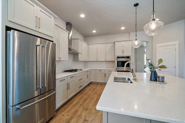 5663 W 96th Ave, Westminster, CO 80020 - kitchen with appliances with stainless steel finishes, wall chimney range hood, light countertops, light wood-style flooring, and recessed lighting