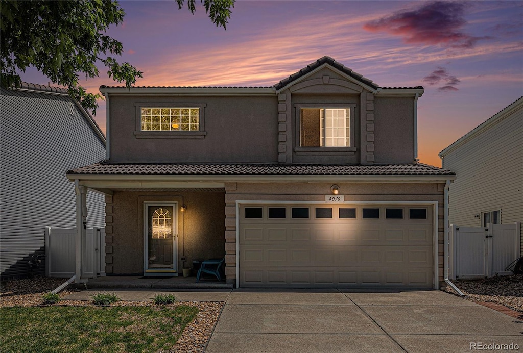 4076 Andes Way, Denver, CO 80249 - traditional-style home featuring covered porch, driveway, a garage, and a tile roof