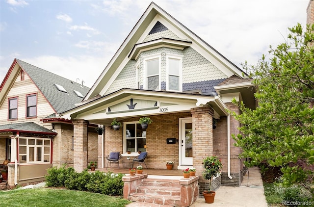 victorian house with a porch and brick siding