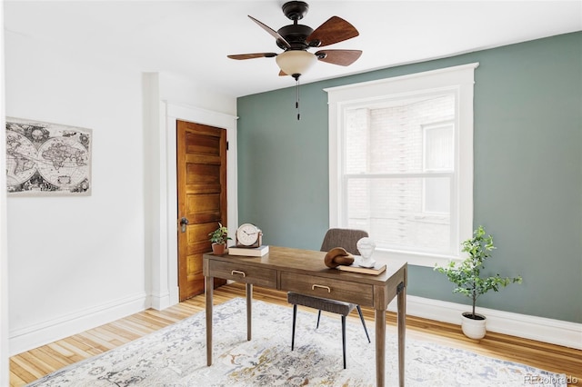 home office with a ceiling fan, baseboards, and light wood-type flooring