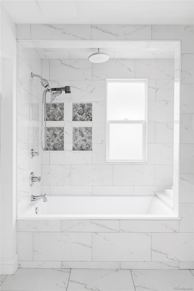 full bath featuring marble finish floor and tiled shower / bath
