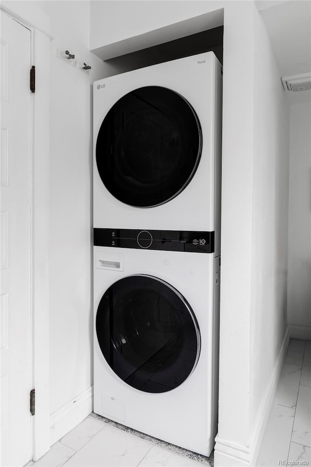 washroom with laundry area, marble finish floor, baseboards, stacked washer / dryer, and visible vents