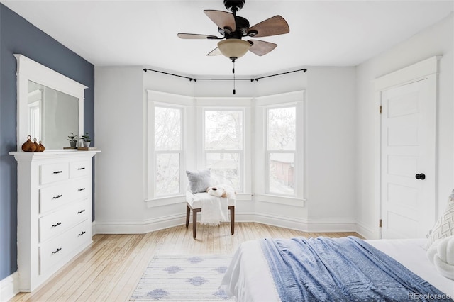 bedroom featuring baseboards, a ceiling fan, and light wood-type flooring