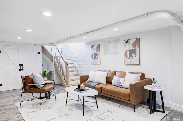 living room with recessed lighting, baseboards, light wood finished floors, and stairway