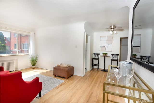 85 N Grant St Unit 27, Denver, CO 80203 - living area with radiator heating unit, wood finished floors, and a ceiling fan