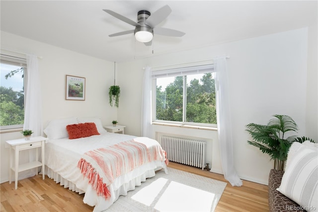 85 N Grant St Unit 27, Denver, CO 80203 - bedroom with radiator heating unit, light wood-type flooring, multiple windows, and a ceiling fan