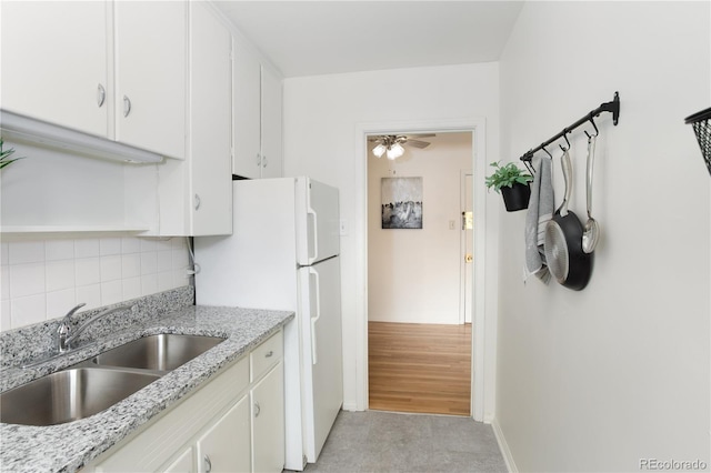 85 N Grant St Unit 27, Denver, CO 80203 - kitchen with tasteful backsplash, freestanding refrigerator, white cabinetry, a ceiling fan, and light stone countertops