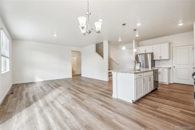 27684 E Byers Ave, Aurora, CO 80018 - kitchen with stainless steel appliances, light wood-type flooring, decorative light fixtures, white cabinets, and recessed lighting