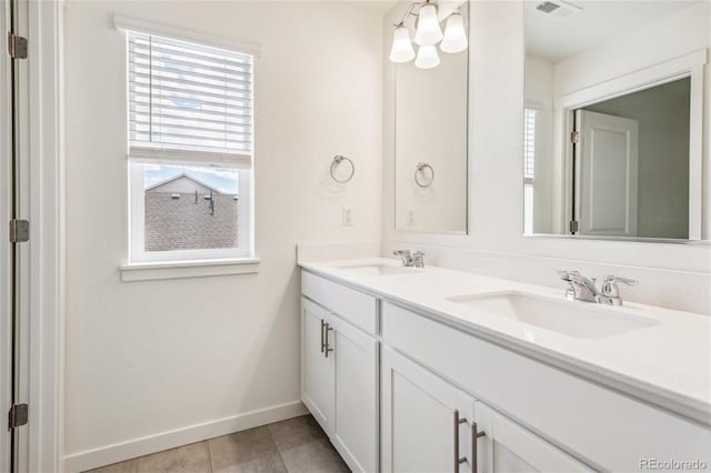 27684 E Byers Ave, Aurora, CO 80018 - bathroom with healthy amount of natural light, baseboards, double vanity, and tile patterned flooring