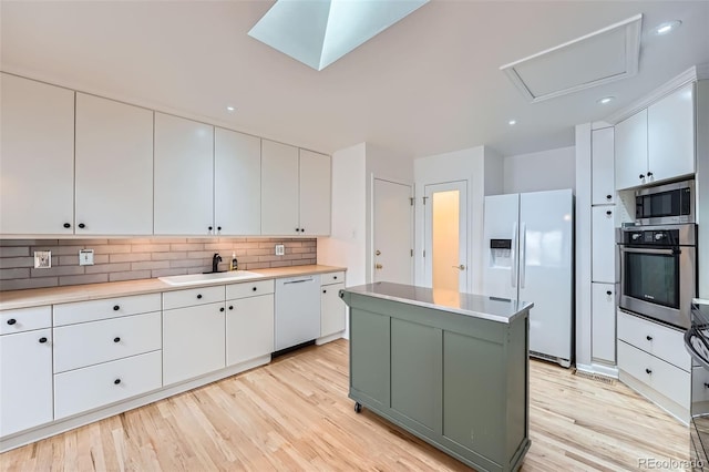 8095 E Lehigh Ave, Denver, CO 80237 - kitchen featuring stainless steel appliances, a sink, white cabinetry, light wood-style flooring, and recessed lighting