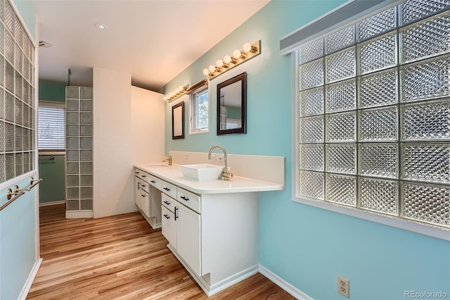 8095 E Lehigh Ave, Denver, CO 80237 - full bathroom with wood finished floors, baseboards, healthy amount of natural light, and double vanity