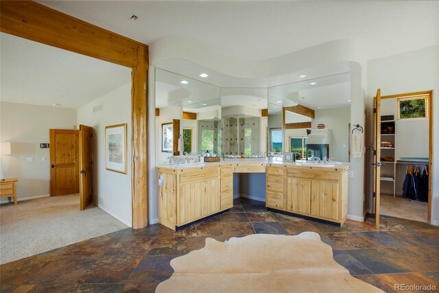 bathroom with vanity, a shower with shower door, and beamed ceiling