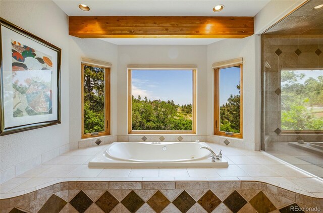 bathroom with a relaxing tiled tub, plenty of natural light, and beamed ceiling