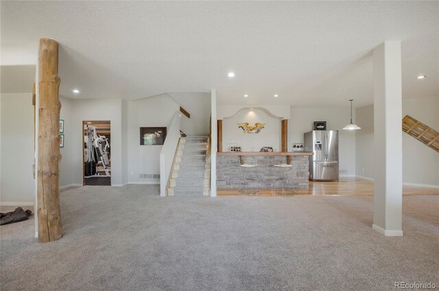 unfurnished living room featuring light carpet and a textured ceiling