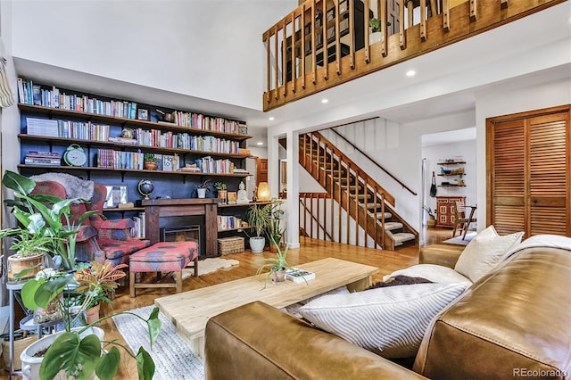 23646 Genesee Village Rd, Golden, CO 80401 - living area with wood finished floors, stairway, a glass covered fireplace, and a high ceiling