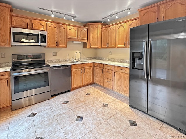 9236 W Euclid Ave, Littleton, CO 80123 - kitchen featuring appliances with stainless steel finishes, a sink, light tile patterned floors, track lighting, and brown cabinets