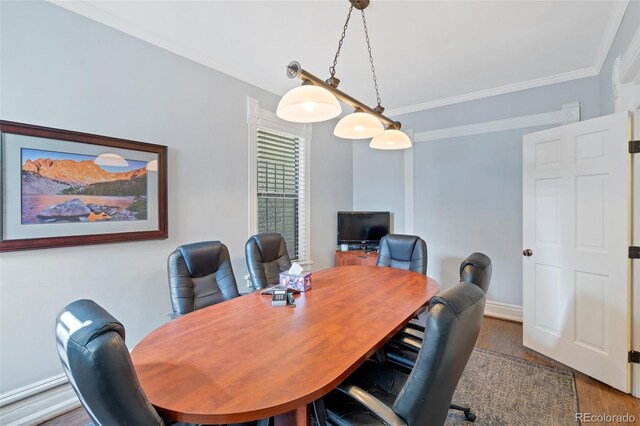 dining space with wood-type flooring and ornamental molding