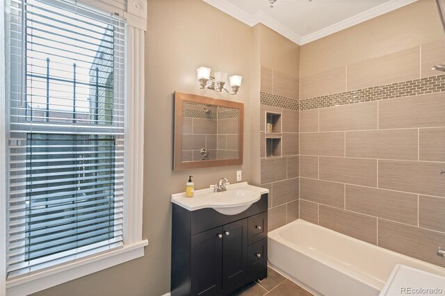 bathroom with tile patterned flooring, a healthy amount of sunlight, tiled shower / bath combo, and vanity