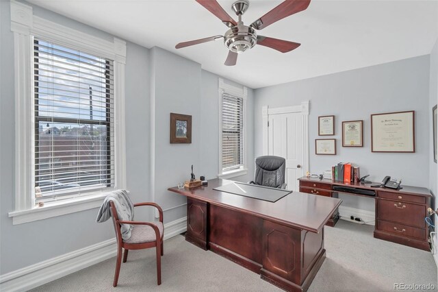 carpeted office space with ceiling fan