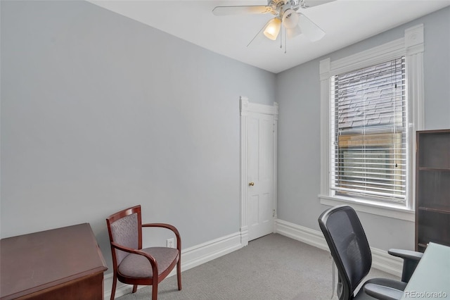 office space featuring a wealth of natural light, ceiling fan, and light carpet