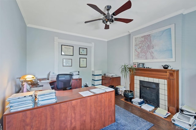 office space with crown molding, ceiling fan, dark hardwood / wood-style flooring, and a fireplace