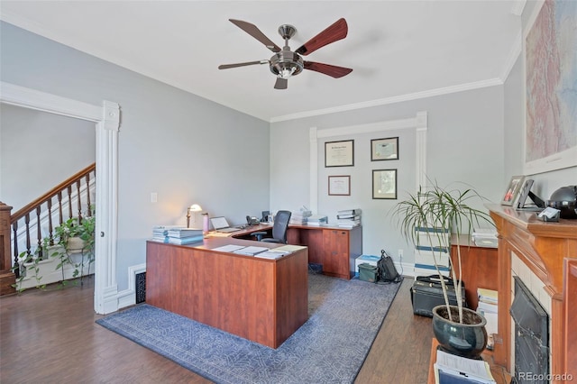 office space featuring ceiling fan, ornamental molding, dark hardwood / wood-style flooring, and a fireplace