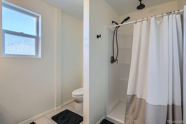 bathroom with tile patterned floors, curtained shower, baseboards, and toilet