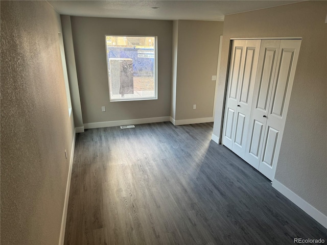 1642 N Lafayette St Unit 5, Denver, CO 80218 - unfurnished bedroom featuring dark wood-style floors, a textured wall, and a closet