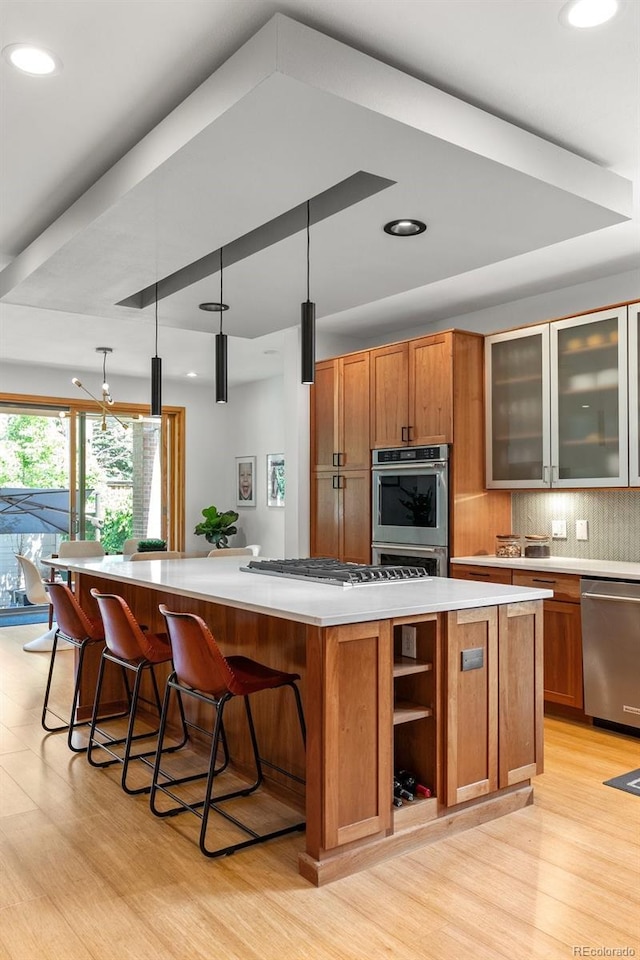 350 Holly St, Denver, CO 80220 - kitchen with a large island, appliances with stainless steel finishes, light wood-type flooring, decorative backsplash, and recessed lighting