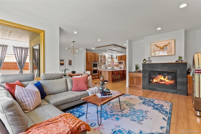 350 Holly St, Denver, CO 80220 - living room with light wood-style floors, a tiled fireplace, healthy amount of natural light, and recessed lighting