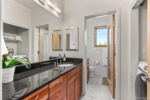 350 Holly St, Denver, CO 80220 - bathroom featuring washer / dryer, toilet, vanity, tile patterned flooring, and baseboards