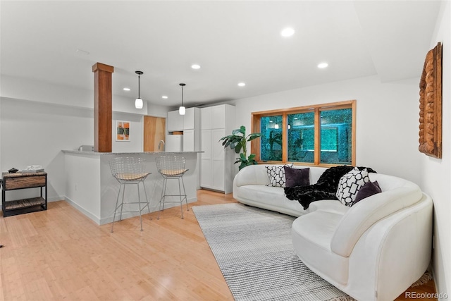 350 Holly St, Denver, CO 80220 - living room featuring recessed lighting, light wood-style flooring, ornate columns, and baseboards