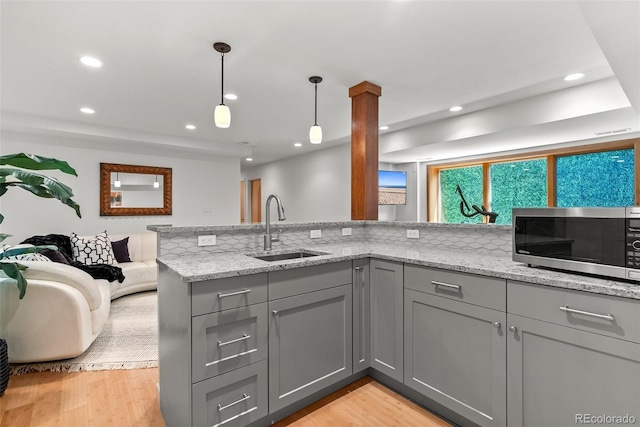 350 Holly St, Denver, CO 80220 - kitchen with gray cabinetry, a sink, stainless steel microwave, light stone counters, and recessed lighting