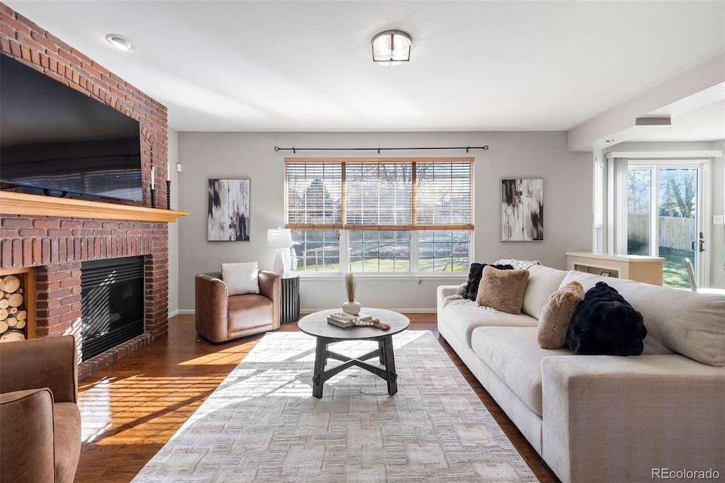 living area with light wood finished floors, a fireplace, and baseboards