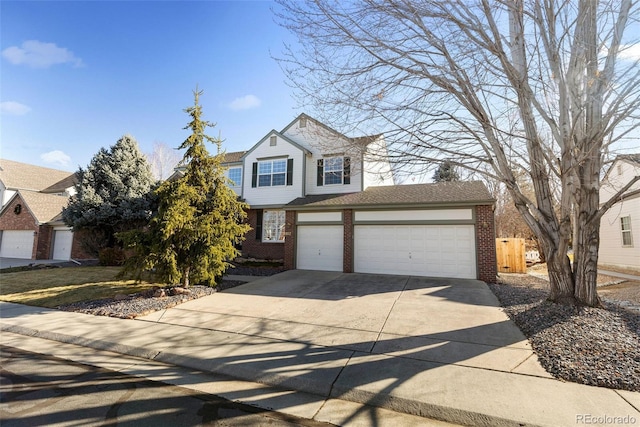 traditional-style home featuring an attached garage, driveway, and brick siding