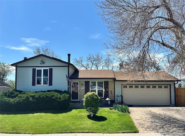 tri-level home with an attached garage, a front lawn, fence, and concrete driveway