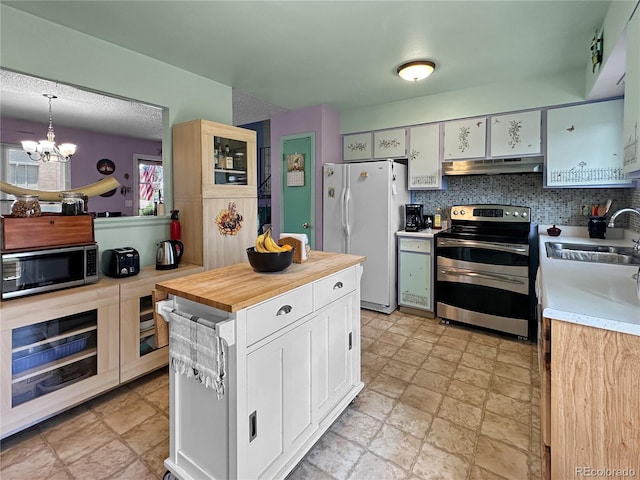 kitchen with white cabinets, appliances with stainless steel finishes, a sink, a chandelier, and under cabinet range hood