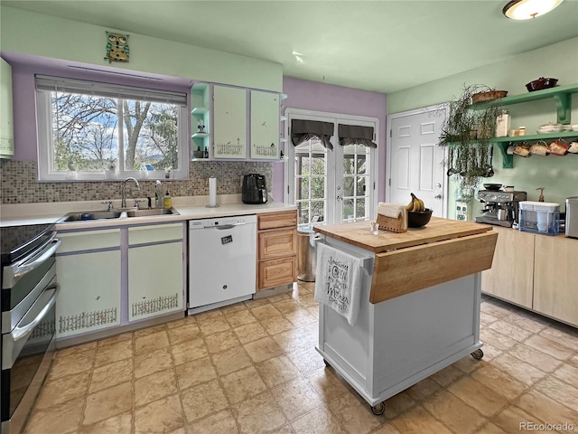kitchen with range with two ovens, open shelves, a sink, and dishwasher