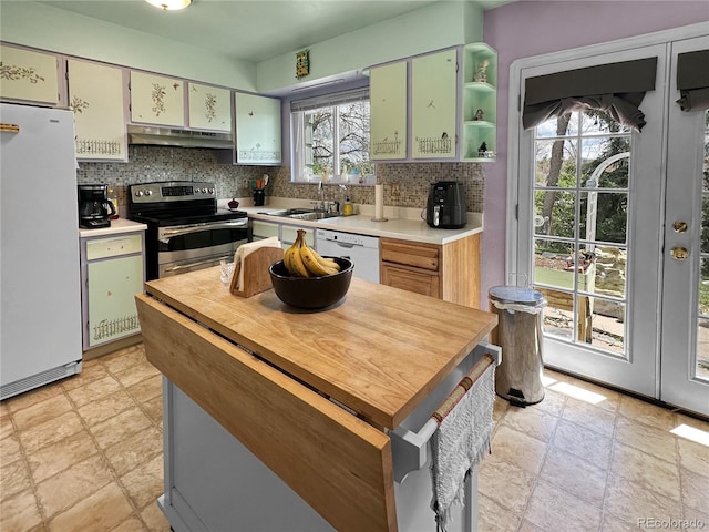 kitchen with a sink, white appliances, stone finish flooring, decorative backsplash, and under cabinet range hood