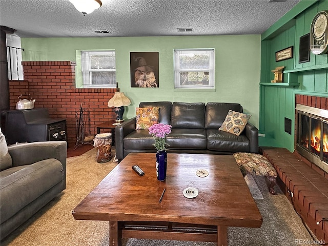 carpeted living room featuring visible vents, a textured ceiling, and a fireplace