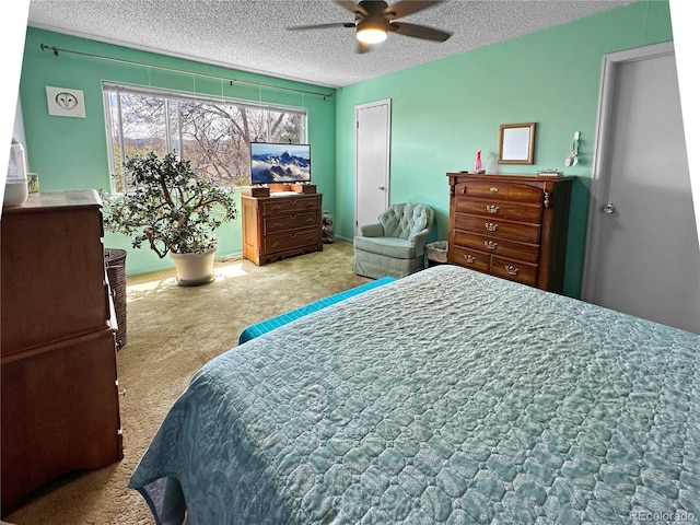 bedroom featuring carpet floors, a ceiling fan, and a textured ceiling