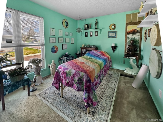 carpeted bedroom featuring a textured ceiling and visible vents