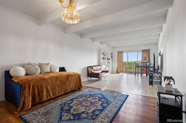 bedroom featuring an inviting chandelier, hardwood / wood-style floors, beam ceiling, and a textured ceiling