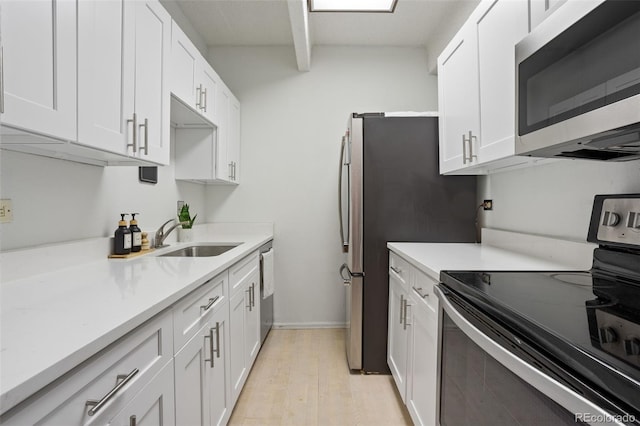 kitchen with appliances with stainless steel finishes, sink, and white cabinets