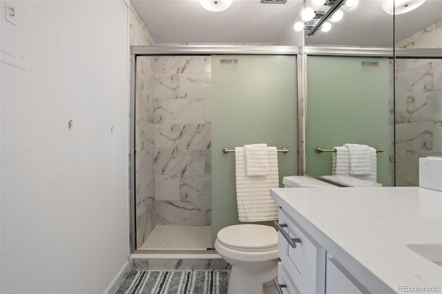 bathroom featuring vanity, toilet, a textured ceiling, and a shower with shower door