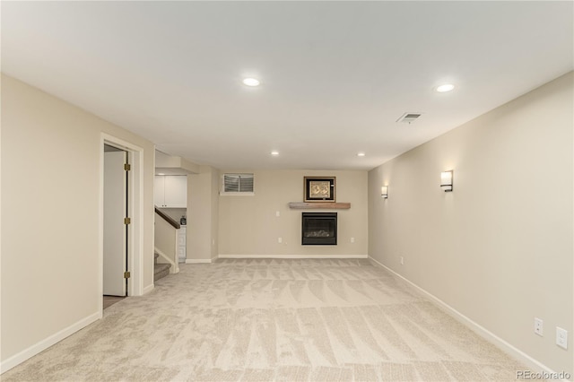 unfurnished living room featuring recessed lighting, baseboards, and light carpet