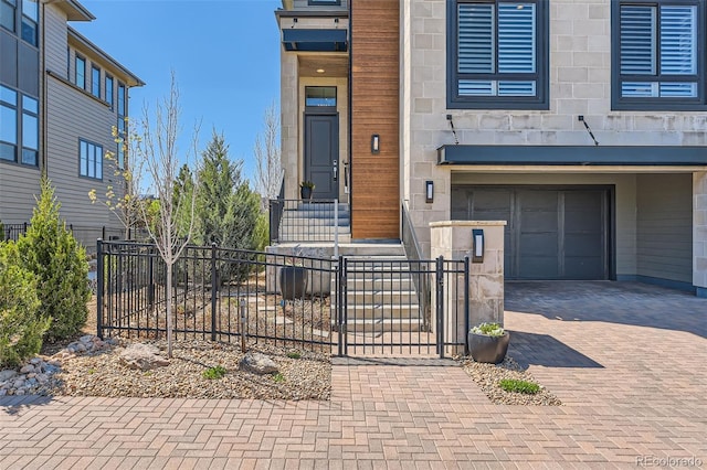 10119 Bellwether Ln, Lone Tree, CO 80124 - view of exterior entry with decorative driveway, a garage, fence, and stone siding