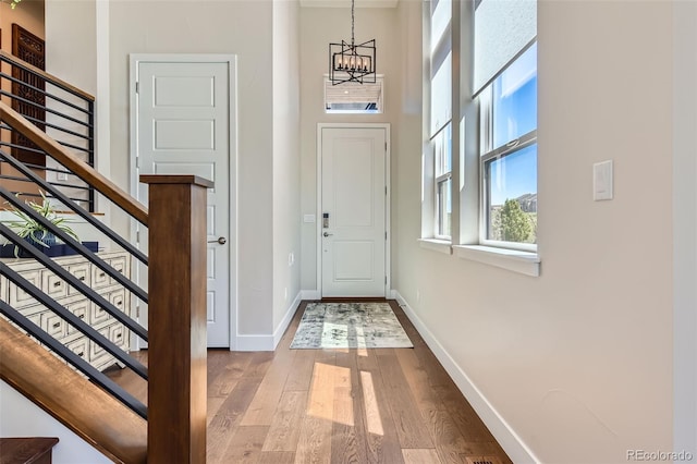 10119 Bellwether Ln, Lone Tree, CO 80124 - doorway to outside with baseboards, an inviting chandelier, wood finished floors, and stairway