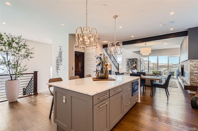 10119 Bellwether Ln, Lone Tree, CO 80124 - kitchen with pendant lighting, a kitchen island, gray cabinets, stainless steel microwave, and dark wood finished floors